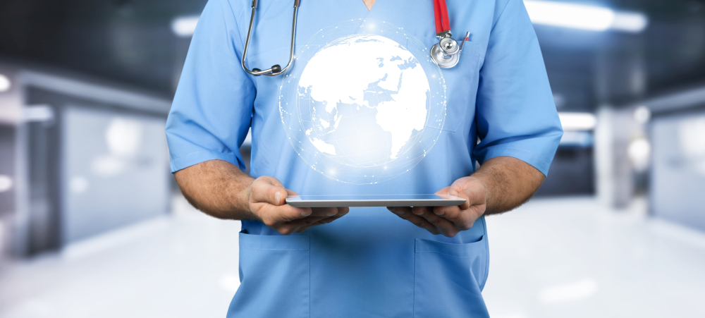 医学专业人员手持一个数字平板电脑，屏幕上方有一个地球仪的图标