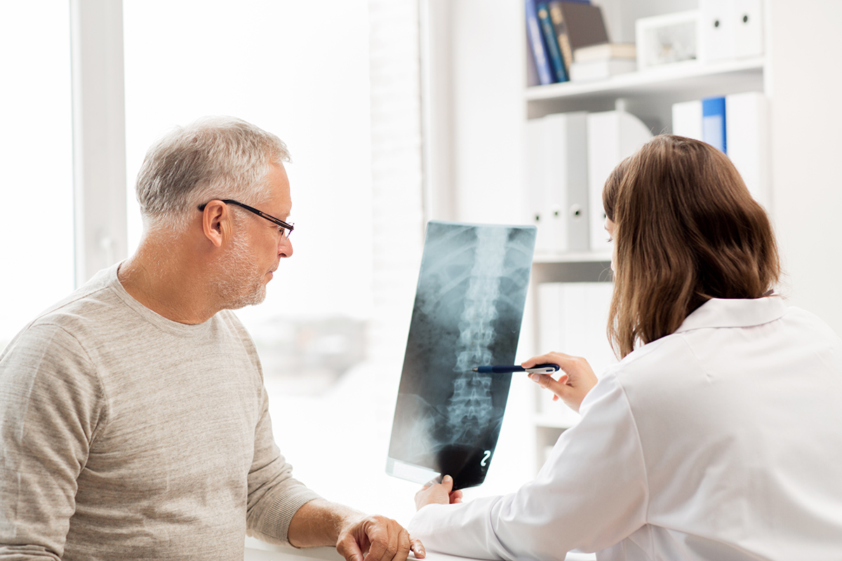 医生和病人在看脊柱x光片